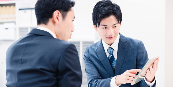 タブレットを使って打ち合わせをするスーツ姿の男性